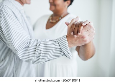 Close-up Of Elderly Man Holding Hand With Woman During Their Slow Dance In Studio