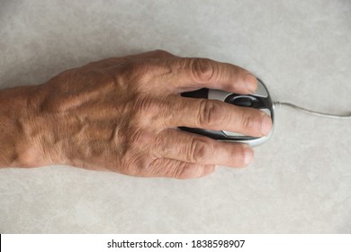 Close-up of an elderly man's hand on a computer mouse. older people are learning new computer technologies. Selective focus, shallow depth of field