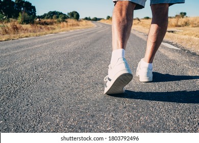 Close-up of an elderly man's legs walking down the road. Concept of vitality