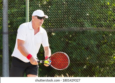 Close-up Of An Elderly Tennis Player Playing Tennis On An Outdoor Court