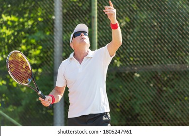 Close-up Of An Elderly Tennis Player Playing Tennis On An Outdoor Court