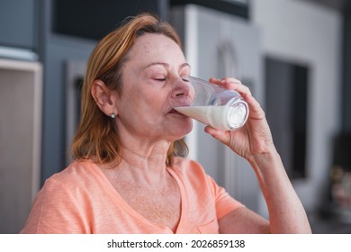 Closeup Of Elderly Woman Drinking A Glass Of Milk To Make Calcium.