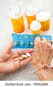 Closeup Of An Elderly Woman's Hands Sorting Her Medication For The Week.