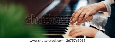 Close-up of elderly and young hands on piano keys. Warm tones, emotional connection, suitable for music lessons or family themes. Wide banner with copy space.