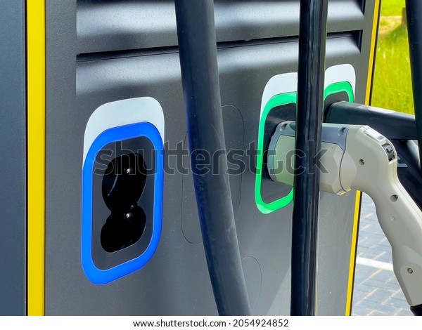 closeup of an electric car charging at a charging\
station with a filling\
pistol
