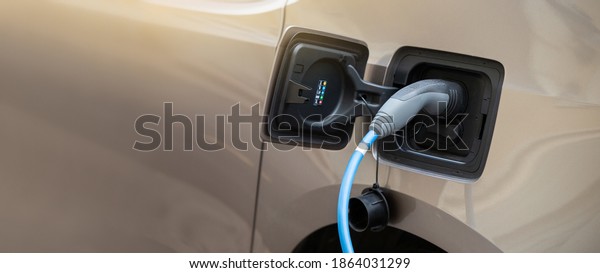Close-up of an\
electric car with connected\
cable