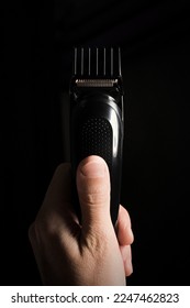 Close-up of Electric shaver machine with nozzle in hand on black background, copy space, vertical. - Shutterstock ID 2247462823