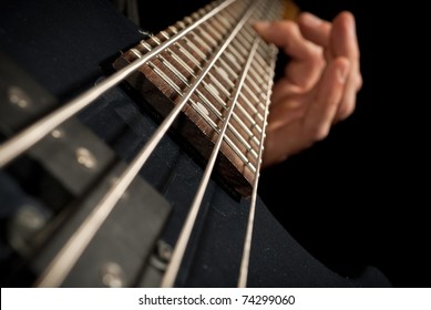 Closeup Of Electrical Bass Guitar Strings With Fingers On It