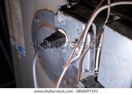 Close-up of electrical power plug and toggle switch on furnace