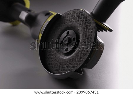 Close-up of electrical saw, grinder for metal works on grey surface. Macro of powerful circular saw equipment for construction works. Carpentry concept