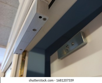 close-up electromagnetic lock mounted on a wooden door to restrict access to the room, access via access card - Powered by Shutterstock