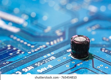 Closeup of electronic circuit board with capacitor blue 