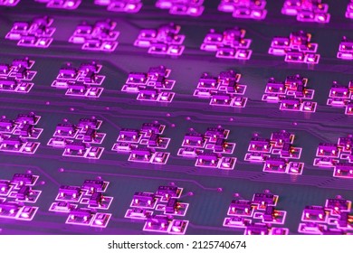 Close-up Of An Electronic Circuit Board With Many SMD Components Illuminated By Ultraviolet Light. Complex Logical Electronic System Built On Smd Components