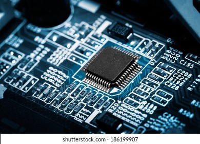 Closeup of electronic circuit board with processor on blue tone.