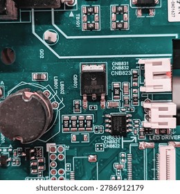 Close-up of electronic components and microchips on a green printed circuit board (PCB).