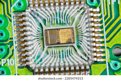 Closeup of electronic integrated circuit die with photodiode array and gold wires on green PCB. Micro chip inside optical computer mouse image sensor in plastic package with round hole and metal pins. - Shutterstock ID 2285474313