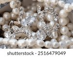 Close-up of an elegant assortment of jewelry, including pearl necklaces and silver diamond-studded pieces. This image captures the luxury and intricacy of fine jewelry, showcasing the beauty and