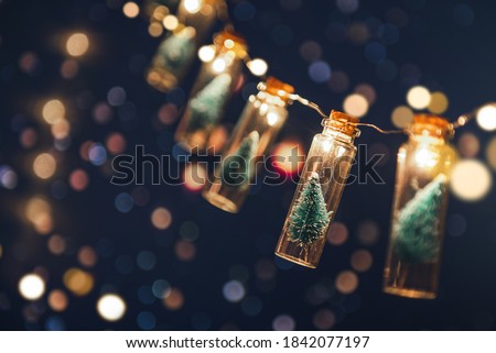 Close-up, Elegant Christmas tree in glass jar with bokeh lights background, copy space. Christmas and new year concept.