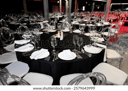 Close-up of an elegant round table setup, plates, glasses, and food dishes in a banquet hall