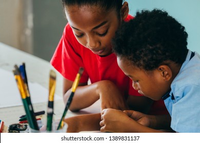 Closeup Of Elementary African American Kids Creatively Drawing And Painting With Brushes And Crayon - Children Creative Education Concept