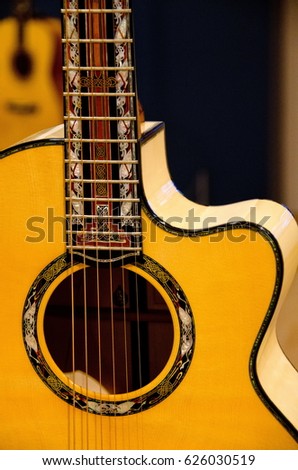 Closeup of elements of  a six strings guitar with dark background
