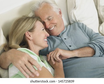 Closeup Elevated View Of A Happy Middle Aged Couple Embracing In Bed