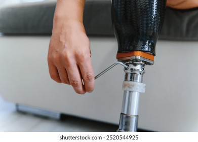 Close-up elevated view of a man adjusting the screws on an artificial prosthetic leg. - Powered by Shutterstock