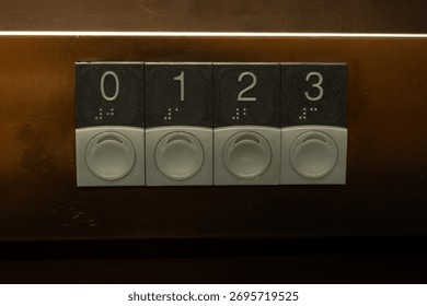Close-up of an elevator control panel with metallic buttons labeled 0 to 3, each featuring Braille markings. Industrial design representing accessibility, navigation, and modern infrastructure.