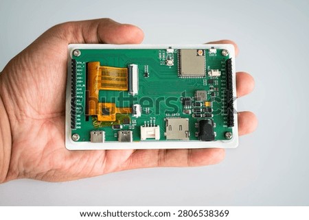 Close-up of an embedded development board held in hand for hardware prototyping, featuring electronic circuitry for IoT, embedded systems, electronics engineering, smart devices, product development and digital technology.