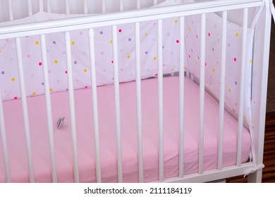 Closeup Of A Empty Baby's Crib With Baby Pacifier