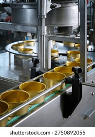 A close-up of empty cans moving along a canning conveyor belt. Modern industrial equipment for the food industry. Selective focus.
