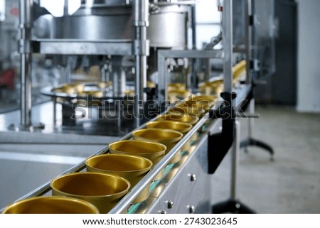 A close-up of empty cans moving along a canning conveyor belt. Modern industrial equipment for the food industry. Selective focus.