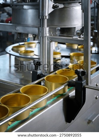 A close-up of empty cans moving along a canning conveyor belt. Modern industrial equipment for the food industry. Selective focus.