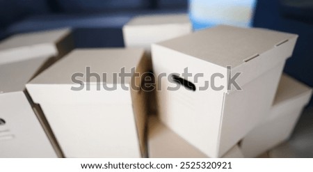 Close-up of empty cardboard boxes with covers container for storage things. Full packages of different stuff sorted separately. Storage, relocation concept