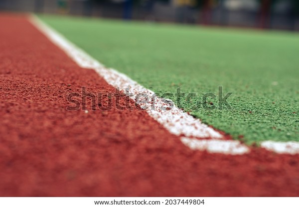 Close-up of an empty soccer field with artificial\
turf. The field for sports games with a coating of crumb rubber.\
Sports field. Sports, active lifestyle. Shooting at ground level.\
Selective focus.