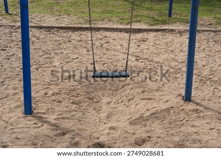 Closeup of empty swing seat and chains in modern playground in Düsseldorf, Germany