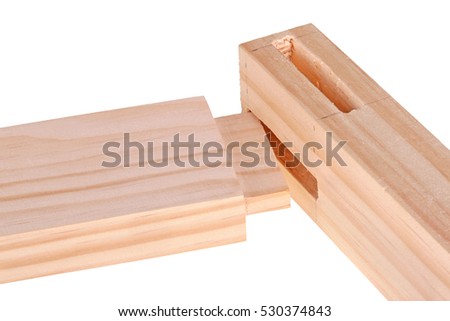 Close-up of the ends of pine boards with two freshly cut woodworking mortises and a tenon isolated against a white background