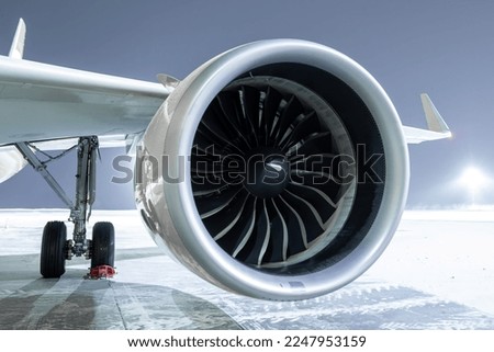 Close-up of engine of big passenger airliner at winter night
