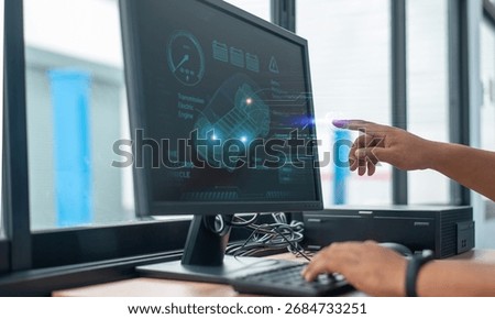 Close-up of engineer using computer with futuristic interface to analyze electric vehicle design, battery system, and power electronics technology.