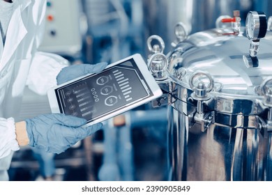 closeup engineer worker tablet in food and drinks factory industry monitor operate control inspecting production line high pressure tank production line. - Powered by Shutterstock