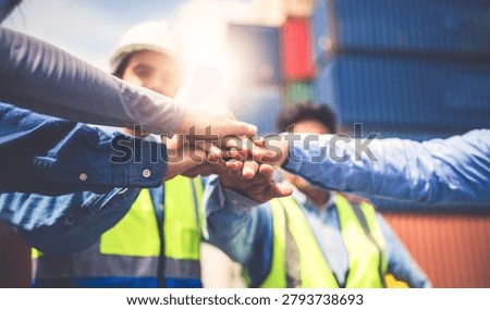 Close-up of Engineering team making pile of hands with cargo container background at sunset. Logistics global import or export shipping industrial concept.