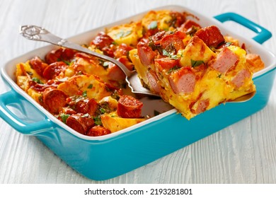 Close-up Of English Muffin Sausage Egg Bake In Baking Dish On White Wooden Table