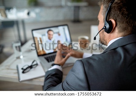 Close-up of entrepreneur using laptop while having online business meeting in the office. 