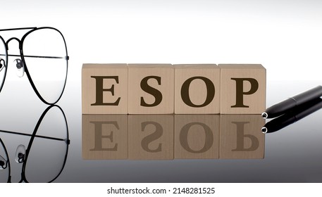 Close-up Of ESOP Wooden Blocks on black background with glasses and pen