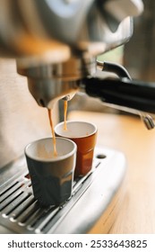 Close-up of an espresso machine brewing two cups of coffee in a cozy kitchen setting.