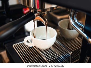 Close-up of espresso pouring from the coffee machine into a coffee cup. Professional coffee brewing