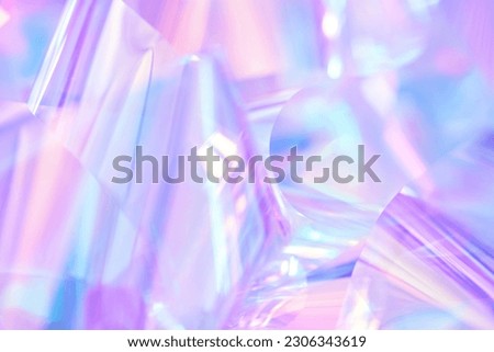 Close-up of ethereal pastel neon blue, purple, lavender, mint holographic metallic foil background. Abstract modern curved blurred surreal futuristic disco, rave, techno, festive dreamlike backdrop