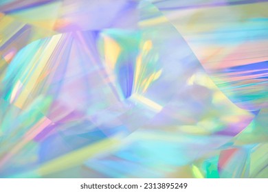 Close-up of ethereal pastel neon mint, blue, purple, yellow holographic metallic foil background. Abstract modern curved soft focused, blurred, surreal futuristic disco, rave, dreamlike backdrop