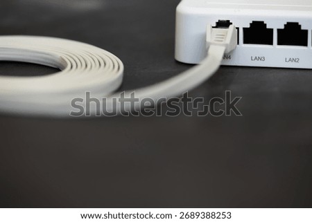 Close-Up of Ethernet Cable Plugged into Router with LAN Ports on Dark Surface