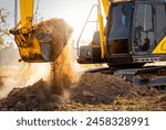 Close-up of excavator at construction site. Backhoe digging soil for earthwork and construction business. Excavating machine at work. Heavy machinery for earth moving and construction site development